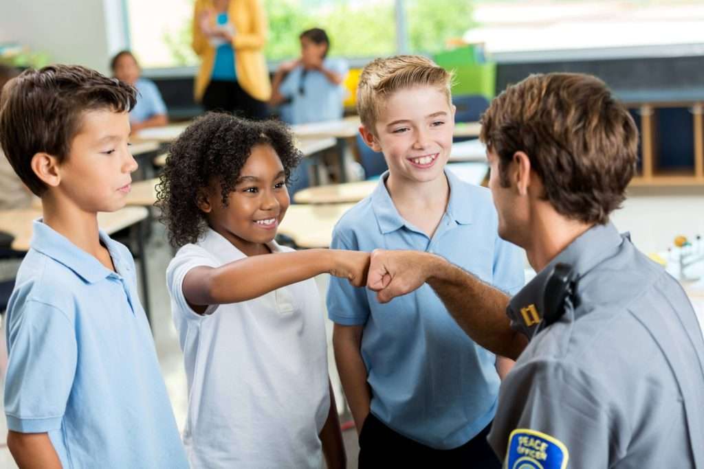 A security guard interacting with young children