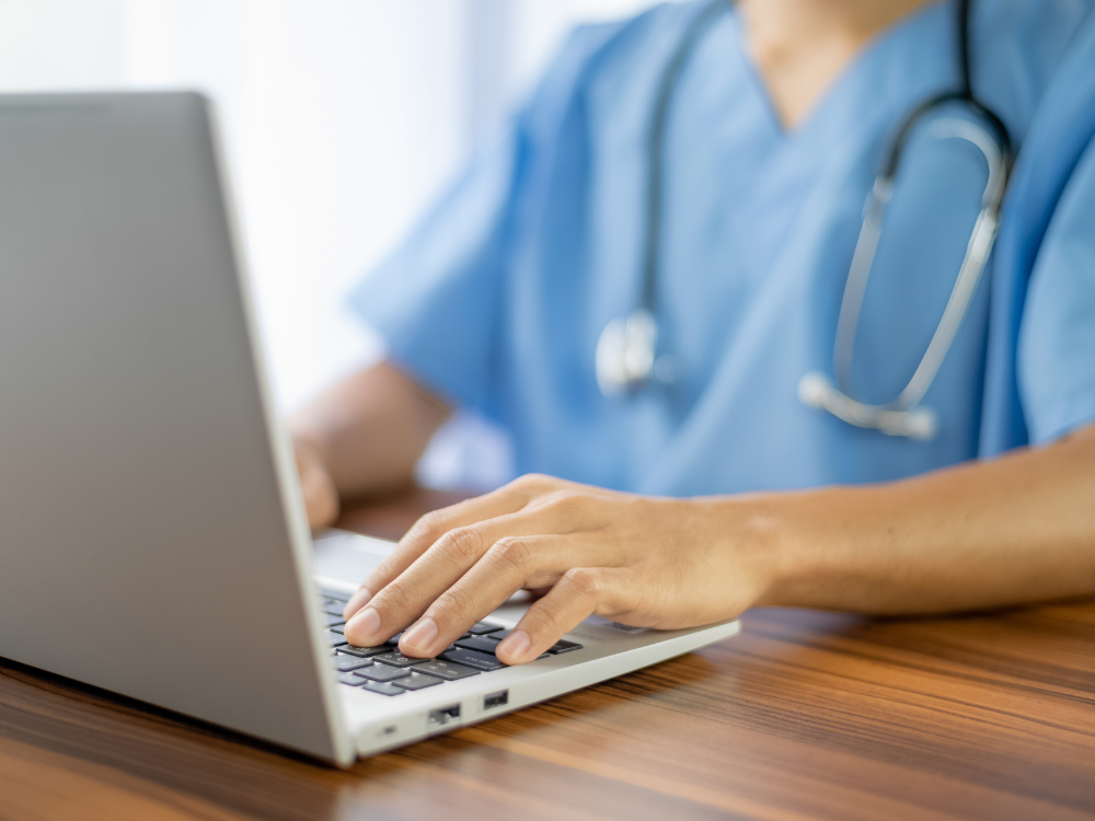 Nurse working at a computer Nurse typing notes at a computer