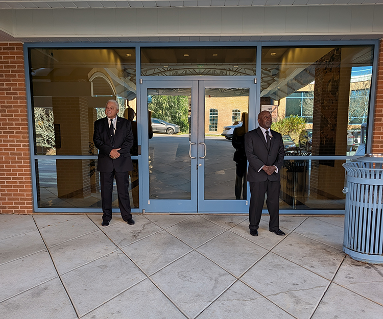Executive Protection security guards protecting an exterior door of an office building