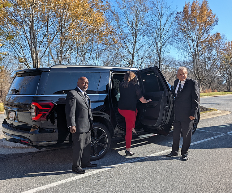 Executive protection security guards protecting a high profile individual entering an suv