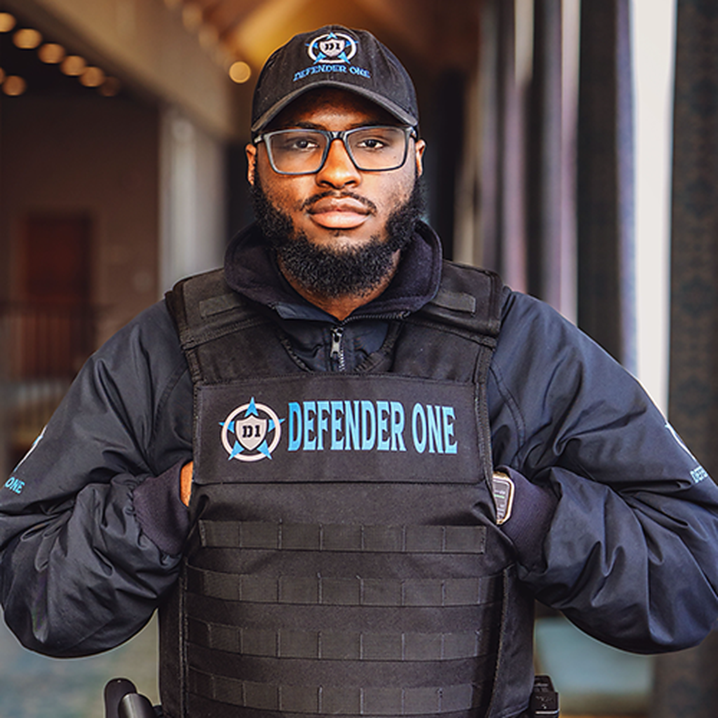 Defender One Security guard in uniform walking into a building